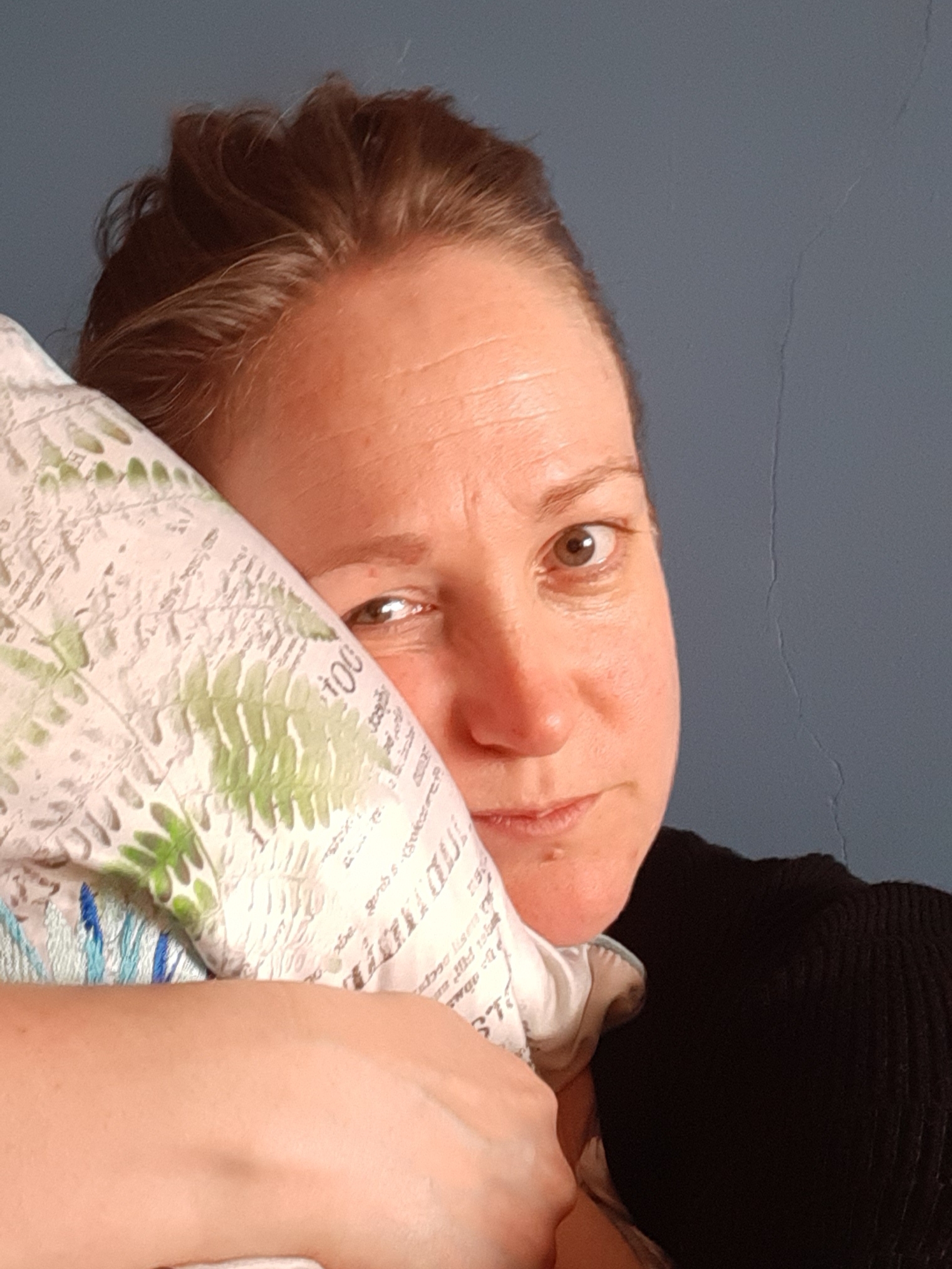 Sam looking tired, cuddling a pillow