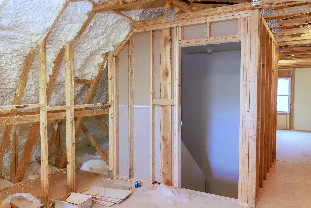 Blown-in insulation being applied to attic flooring for energy efficiency in a home near Astor, Florida