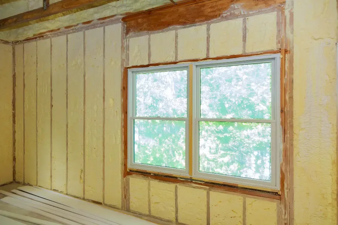 Blown-in insulation being applied to attic flooring for energy efficiency in a home near Astor, Florida
