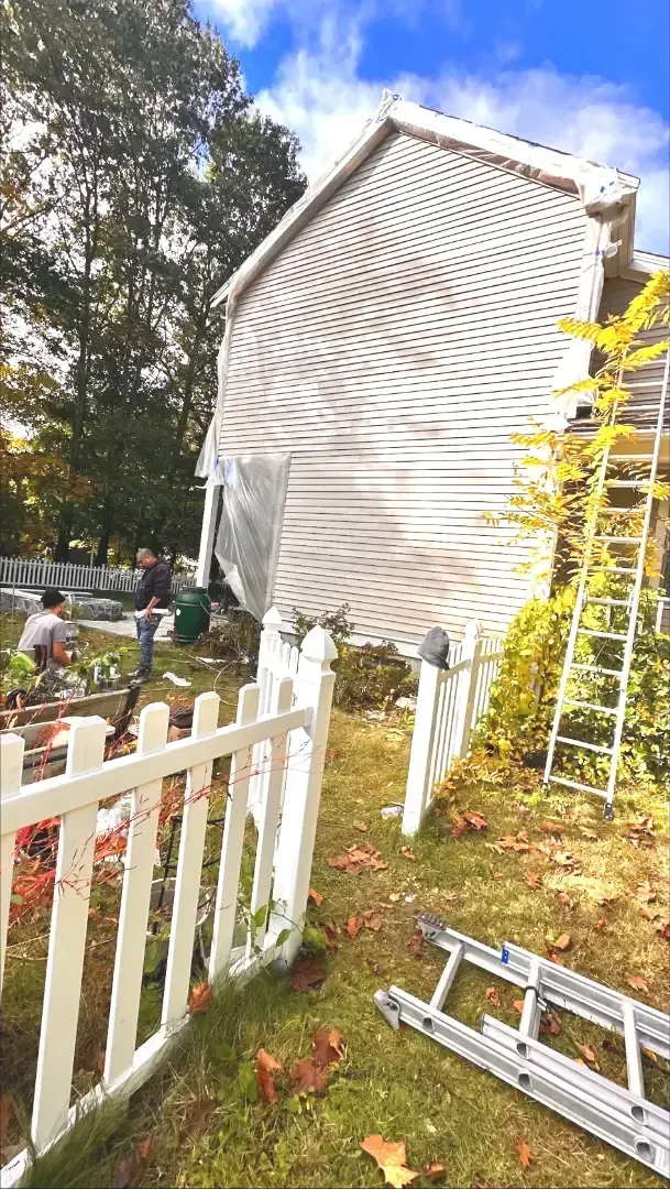 Exterior house painting showing freshly painted siding and trim on a Waltham, MA home