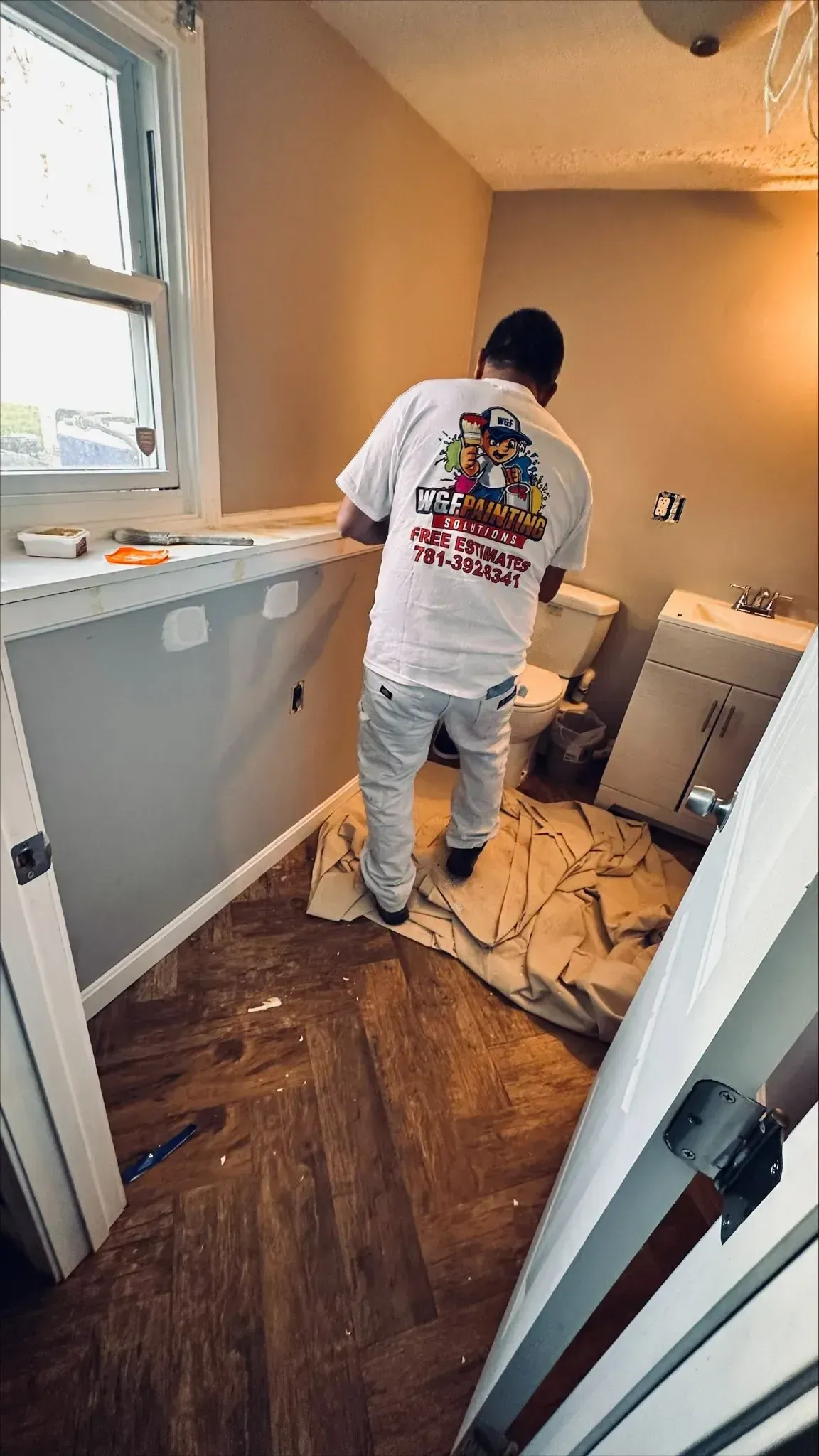 W&F Painting Solutions interior painter working in Arlington MA bathroom during wall preparation