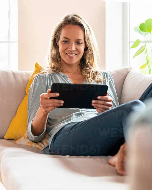 Contented woman relaxing and looking at a tablet