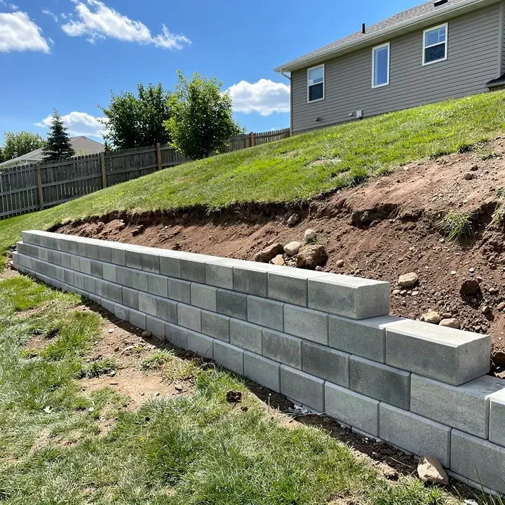 Retaining wall under construction with drainage gravel visible at a job site in Sheboygan, Wisconsin.