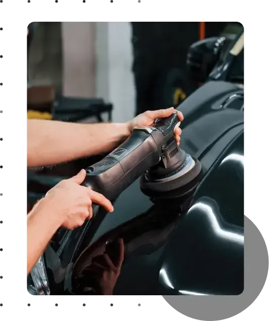 A person polishing the exterior of a  black car, enhancing its shine and appearance
