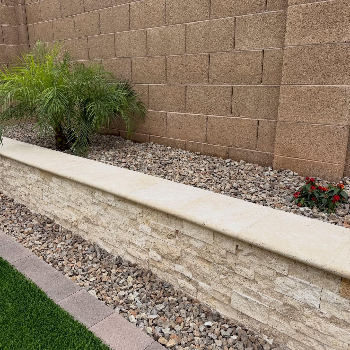 Stacked stone retaining wall with travertine cap, gravel border, and turf edge, AZ Elevate
