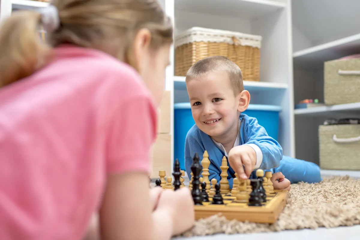 siblings laying chess