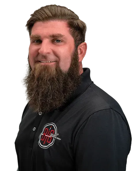 Smiling man with a thick beard in a black polo shirt on a solid blue background