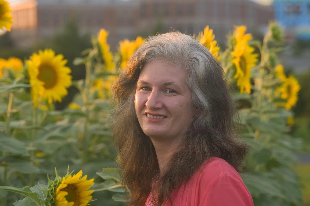 short-haired black cat besides brown wooden table