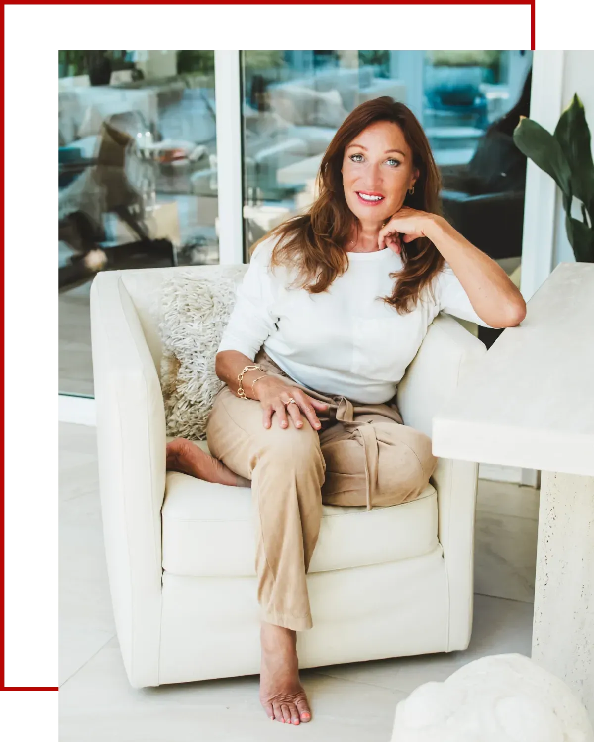 Jackie Bedford seated on a sofa, wearing a cream trousers and white top