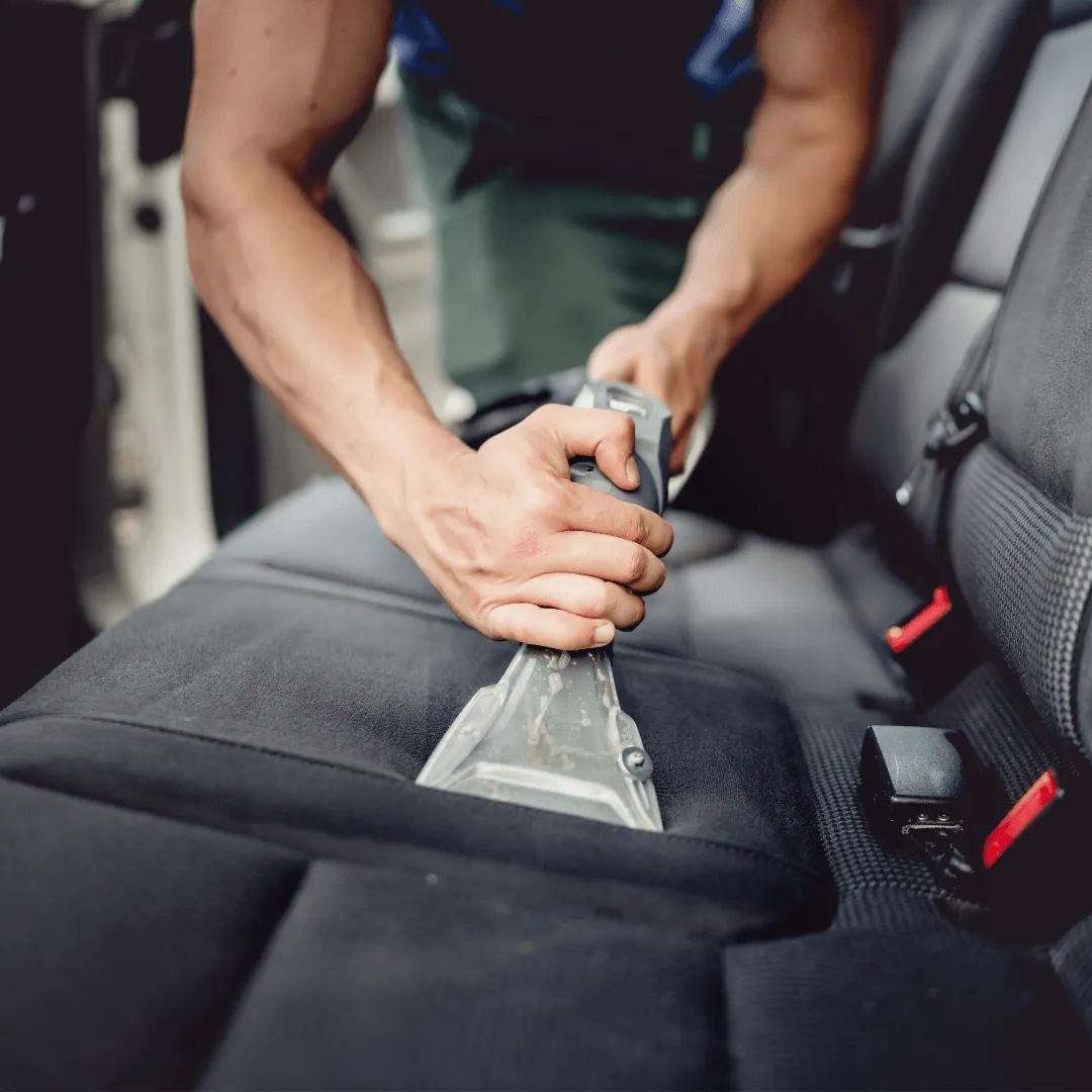 Man cleaning seats of car