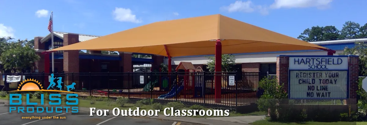 Outdoor classroom with large shade canopy at Hartsfield Elementary School, featuring Bliss Products and Services signage