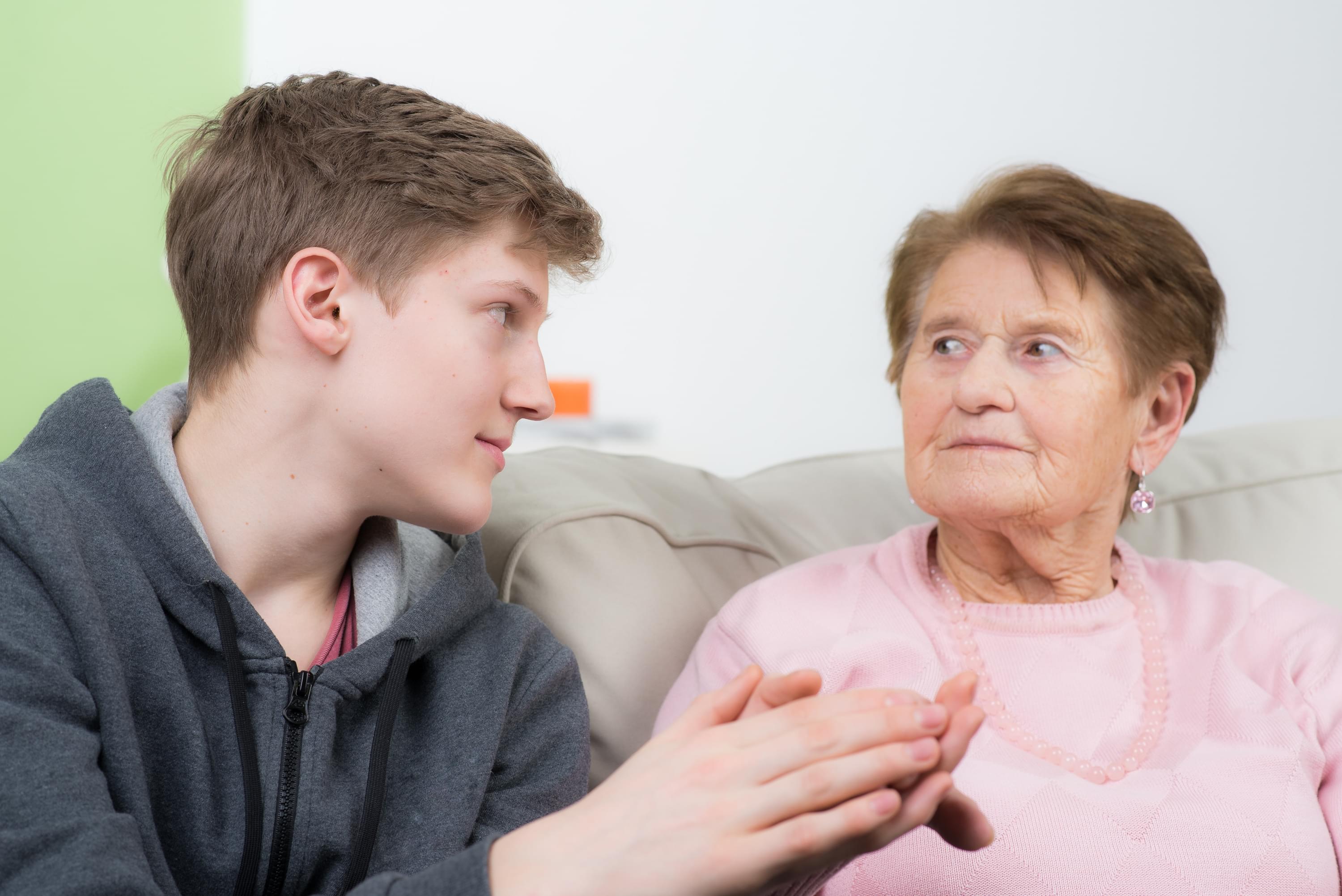 Male young carer looking after an older lady