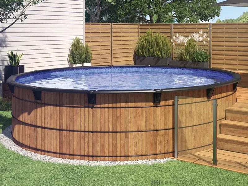 Image d'une piscine hors-terre en bois, installée dans un cour arrière. Le balcon qui y mène est en bois et il y a plusieurs plantes derrière la piscine.