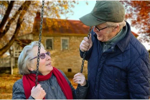 elderly couple talking to each other with a smile