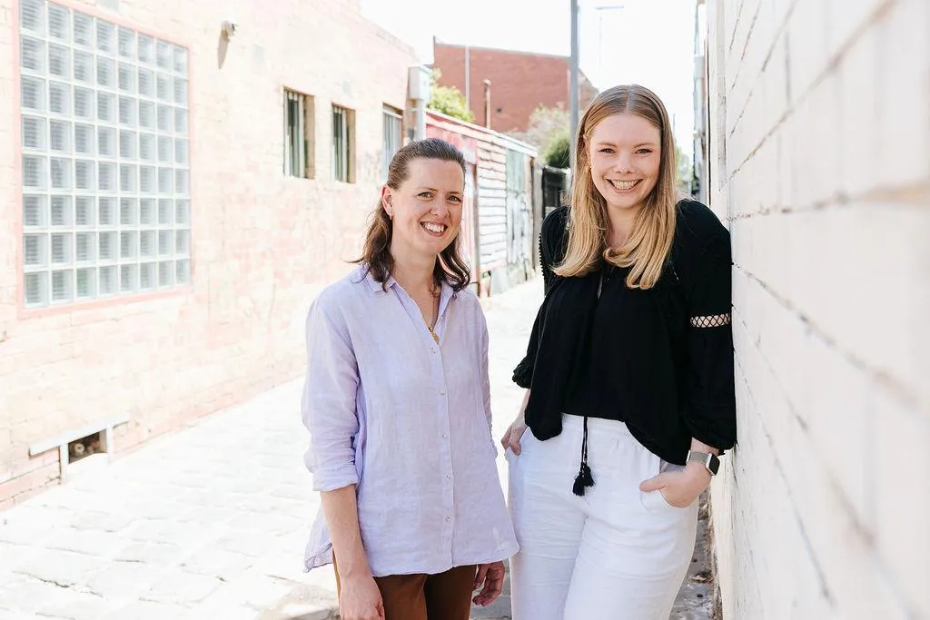 Erin Lyall and Ashlea O'Loughlin from Social Season Agency Ststanding against white wal