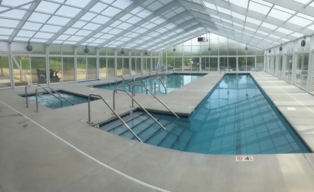 Indoor aquatic center commercial pool with separate lap pool, spa, and wheel chair accessible pool.
