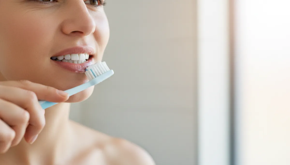 Person practicing good oral hygiene by brushing teeth carefully