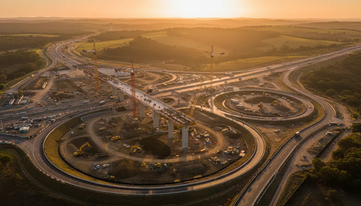 Photorealistic aerial view of a major Australasian highway construction site at golden hour