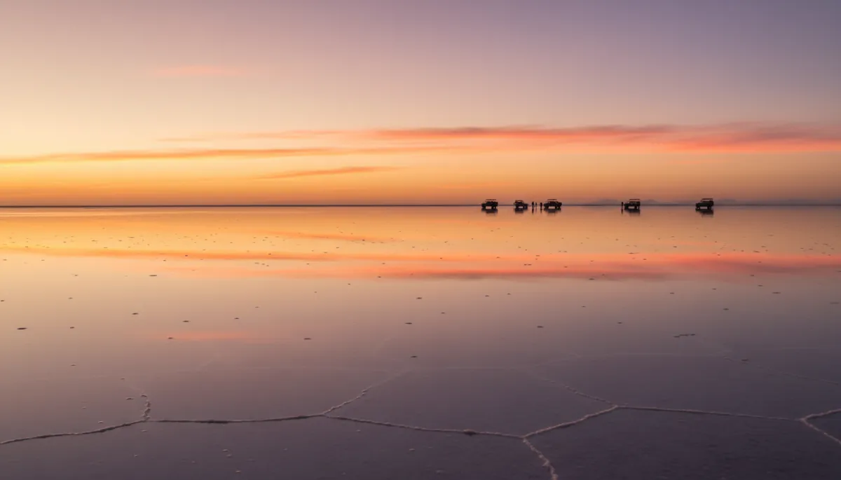 Amanecer naranja y rosa reflejado en el espejo de agua del Salar de Uyuni
