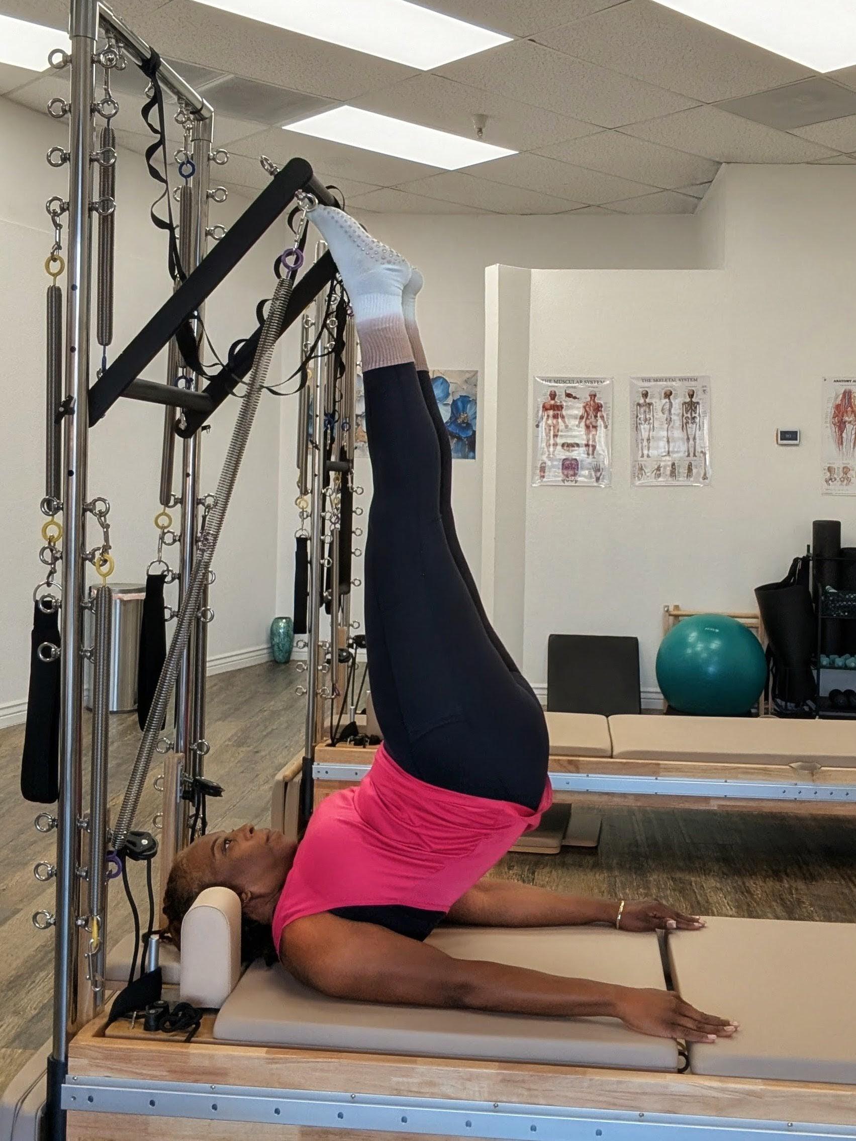 Boutique Pilates Instructor stretching gracefully in natural light