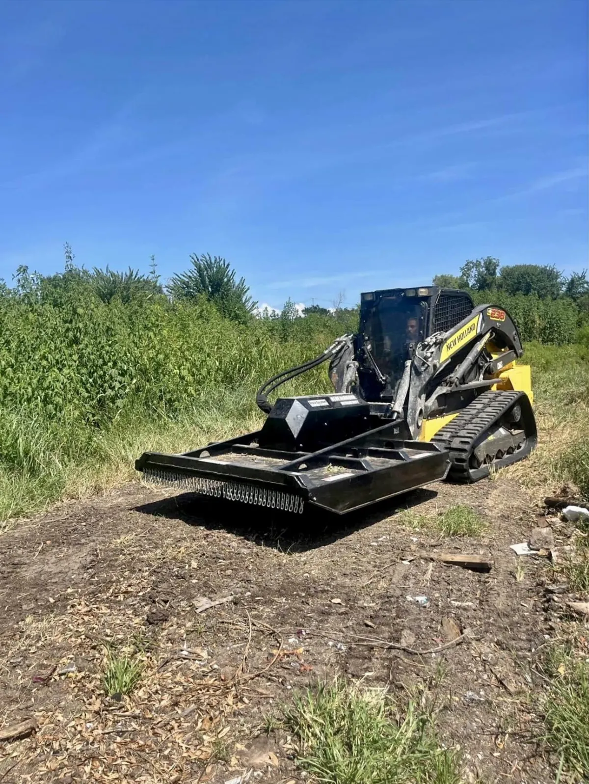 Heavy machinery clearing land and preparing soil for new sod
