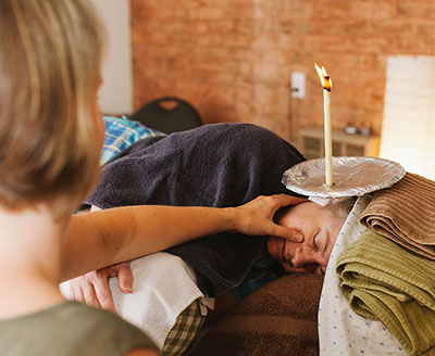 Client enjoying a relaxing 30-minute foot reflexology or energy healing add-on after ear candling