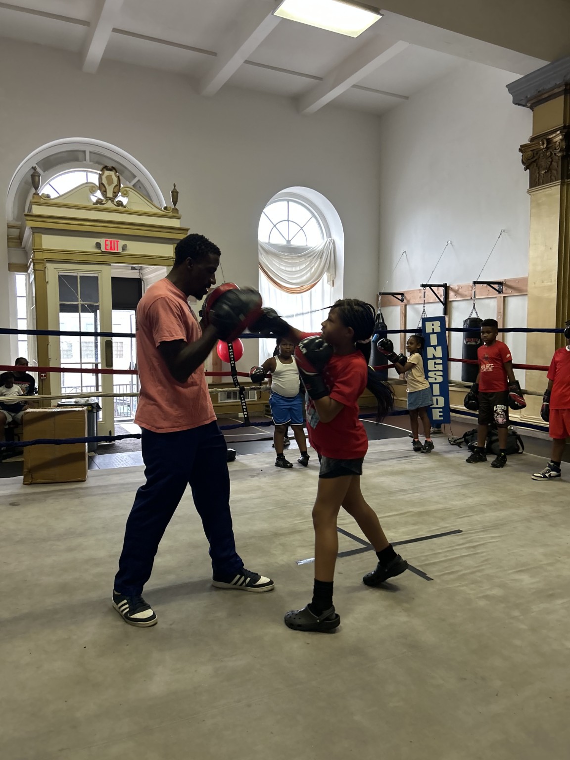 Coach holding mitts for youth pad work training