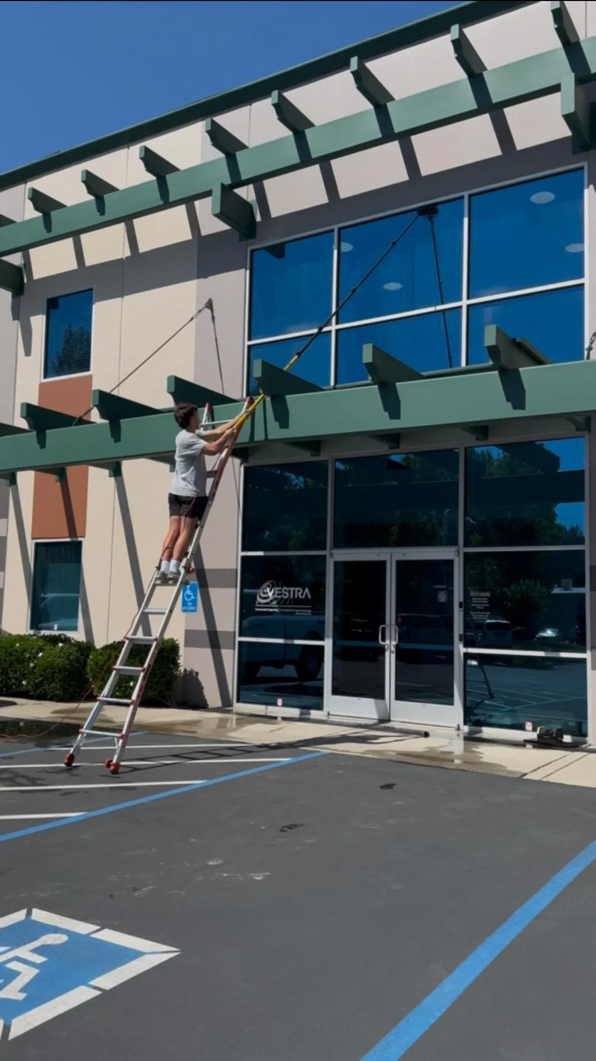 Technician cleaning business windows