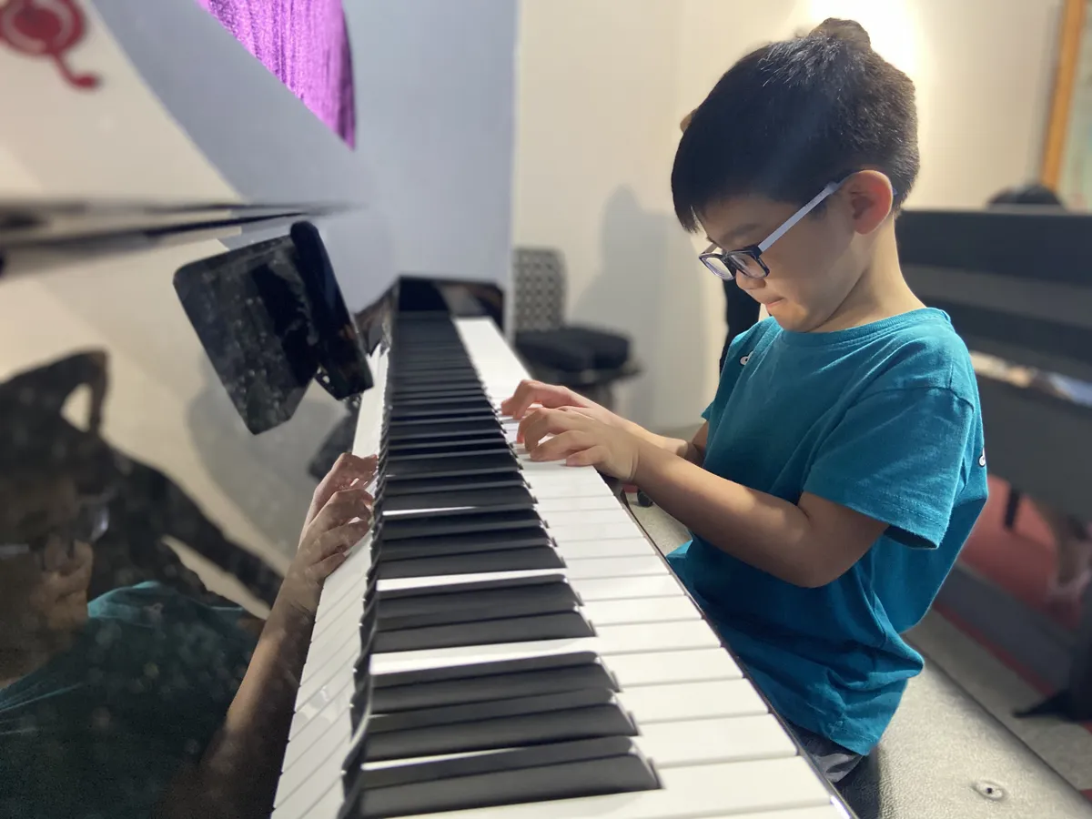 Boy playing piano during a lesson