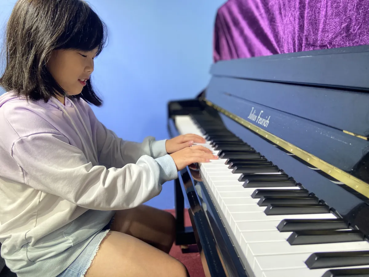 Student playing piano during a lesson