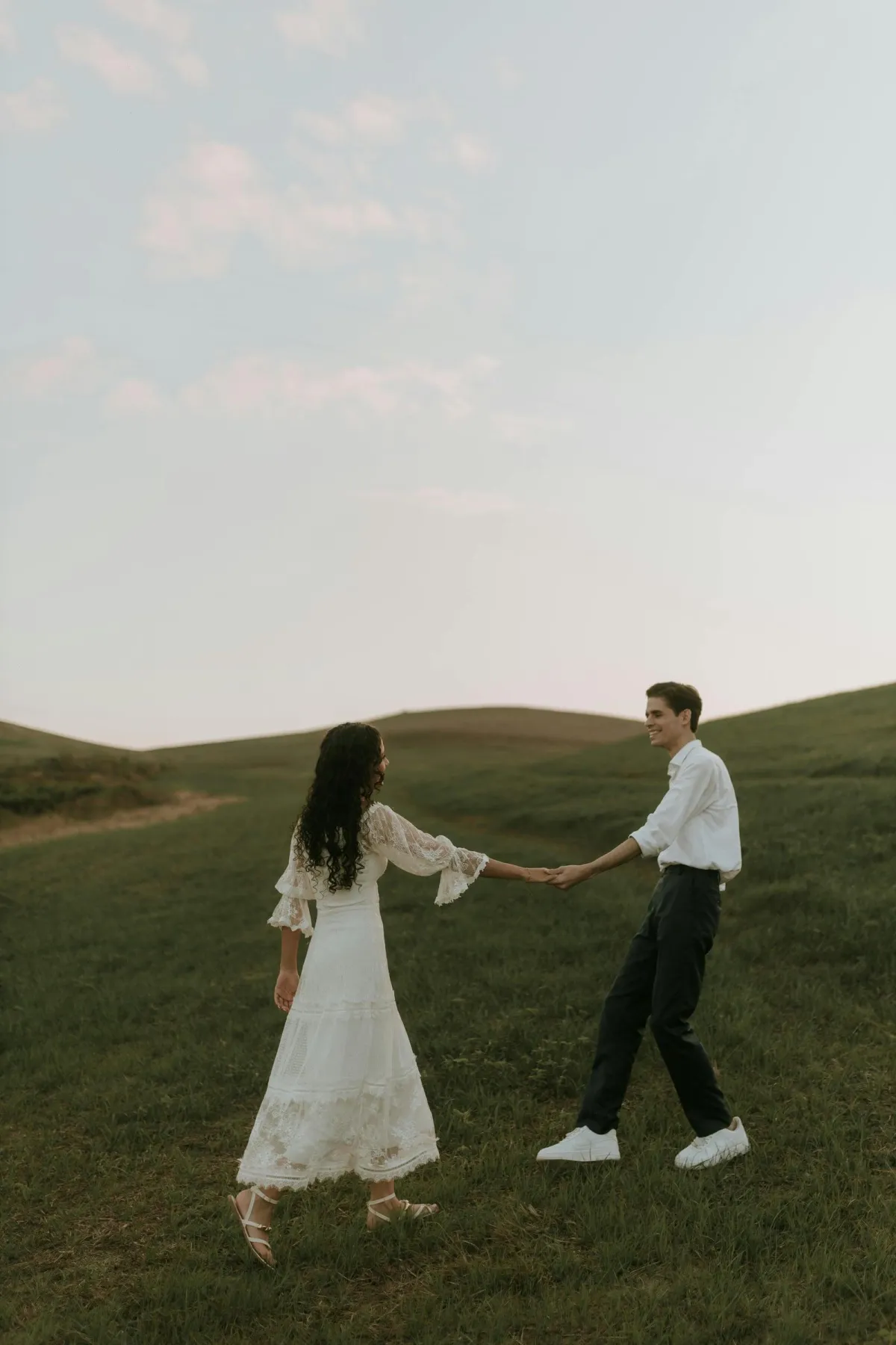 Natalie and Callum holding hands in countryside field