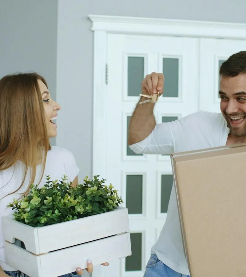 Happy couple unpacking boxes moving into new home