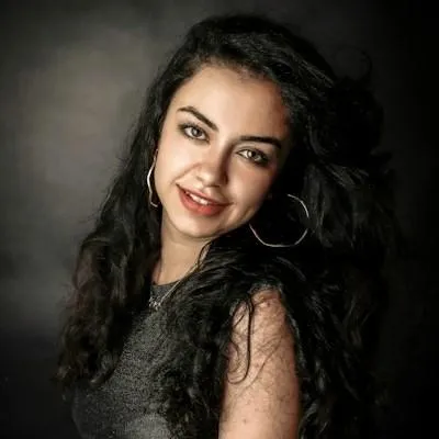 a woman with long black hair smiling at the camera