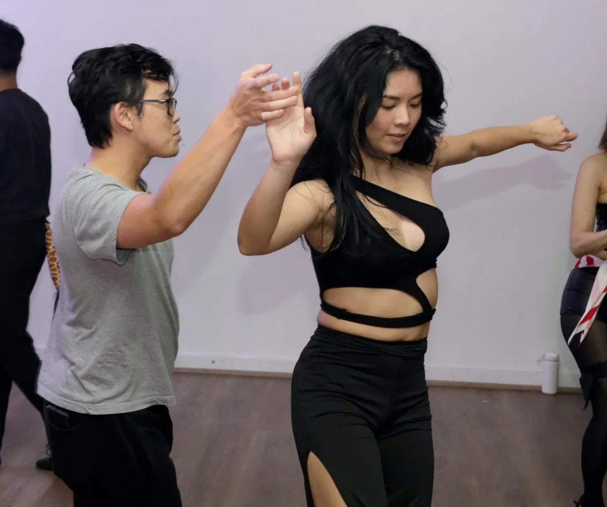 Two women laughing while practicing partner dancing steps