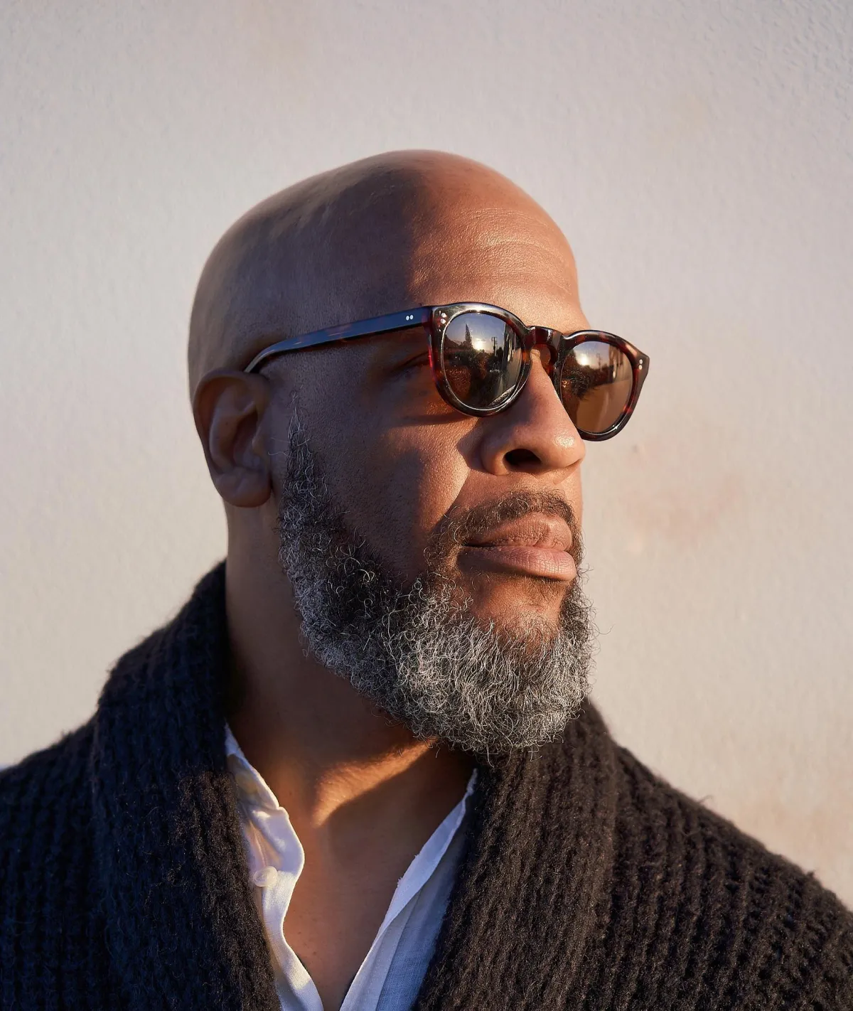 Stone Gye portrait, somatic practitioner and Lomi Lomi guide, wearing sunglasses and a textured sweater.