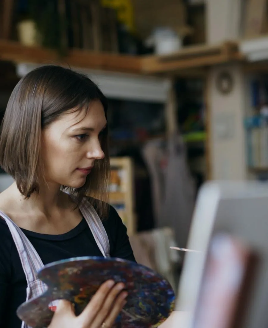 Aria Eisele working on layered metal and glass artwork in studio