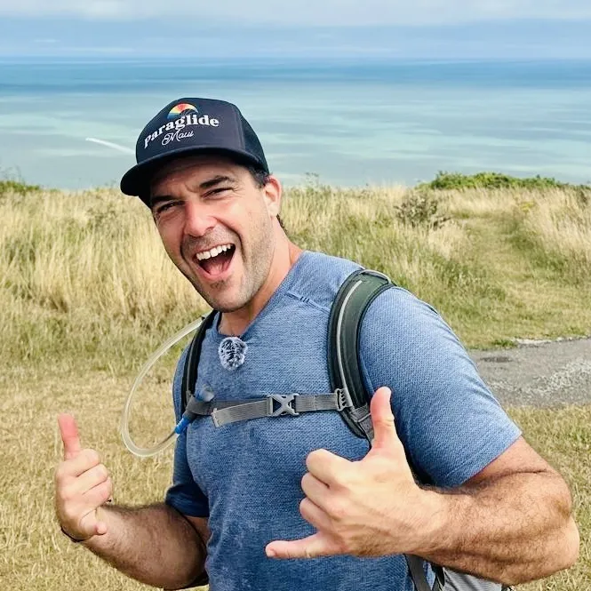 John Patrick Morgan outdoors smiling and giving a shaka
