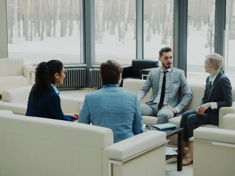 Four professionals in a modern office meeting space