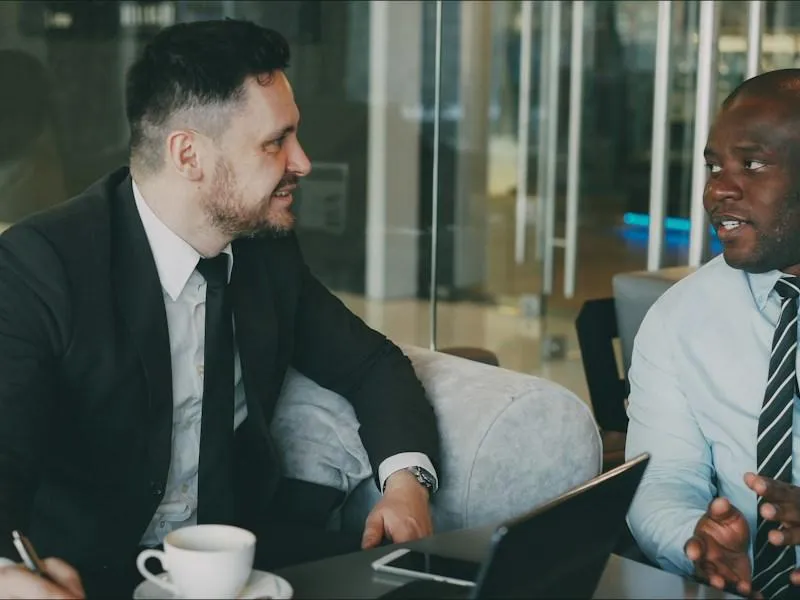 Two businessmen in suits in a confidential executive coaching conversation