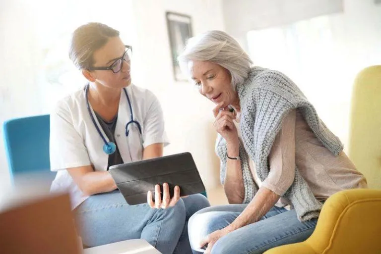 Compassionate doctor consulting with patient using tablet