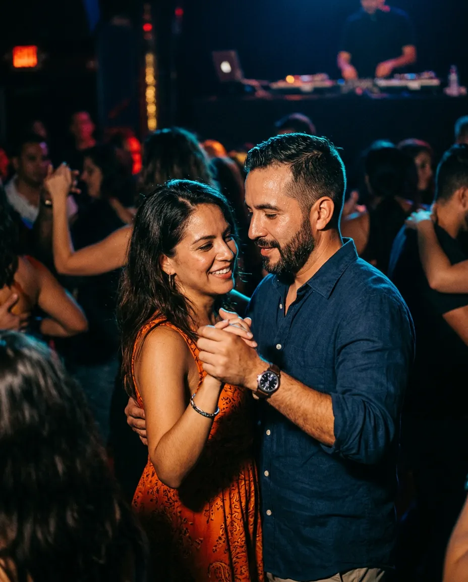Authentic Latin social dancers smiling and connecting under warm club lights