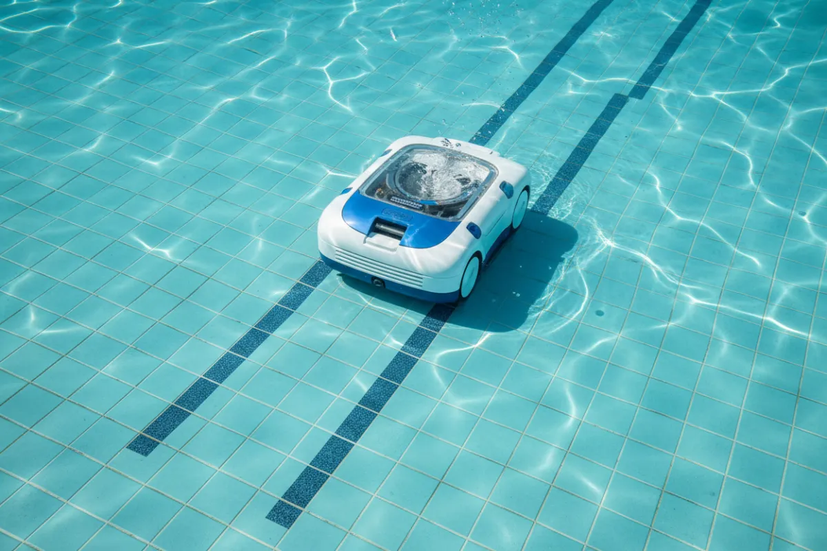 Pool vacuum mid-cleaning leaving clean tracks on the pool floor