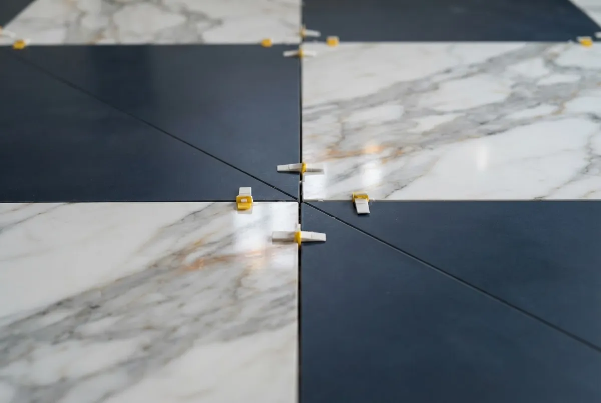 Large format porcelain and natural marble stone tile installation with rectified grout lines