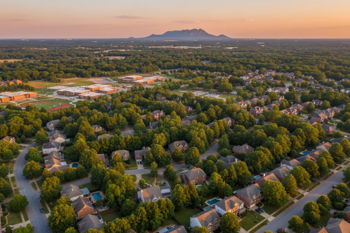 Aerial view of West Cobb neighborhoods at golden hour with Kennesaw Mountain in the distance.