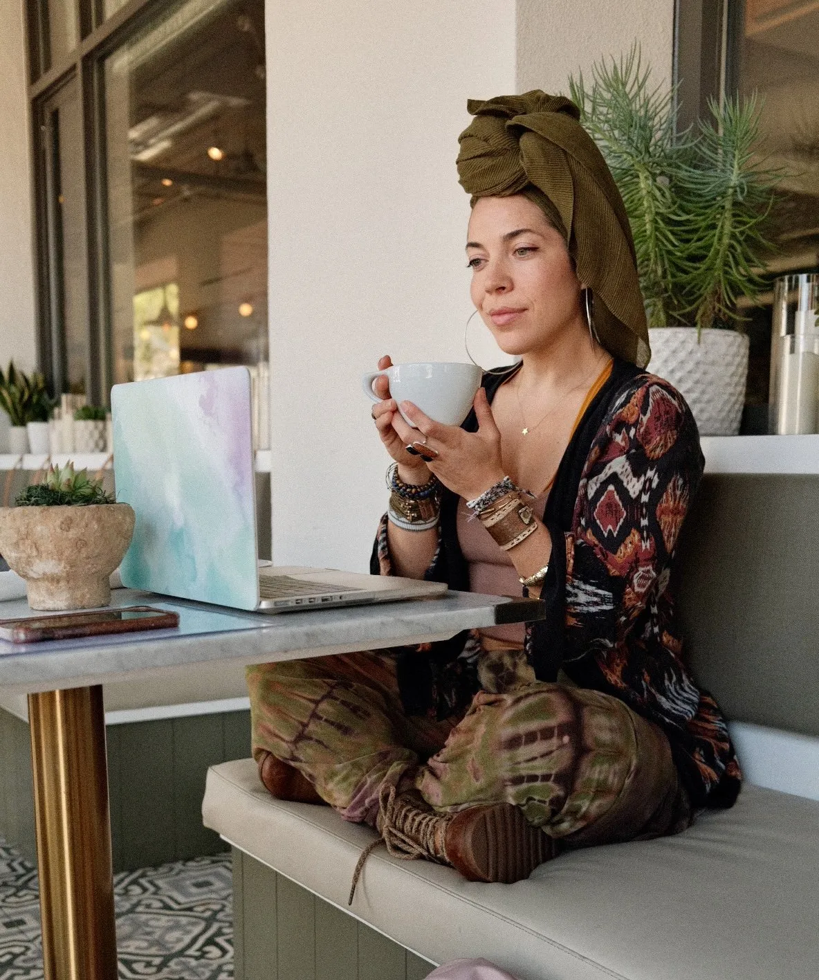 Featured image of a woman at a cafe with laptop holding a white mug