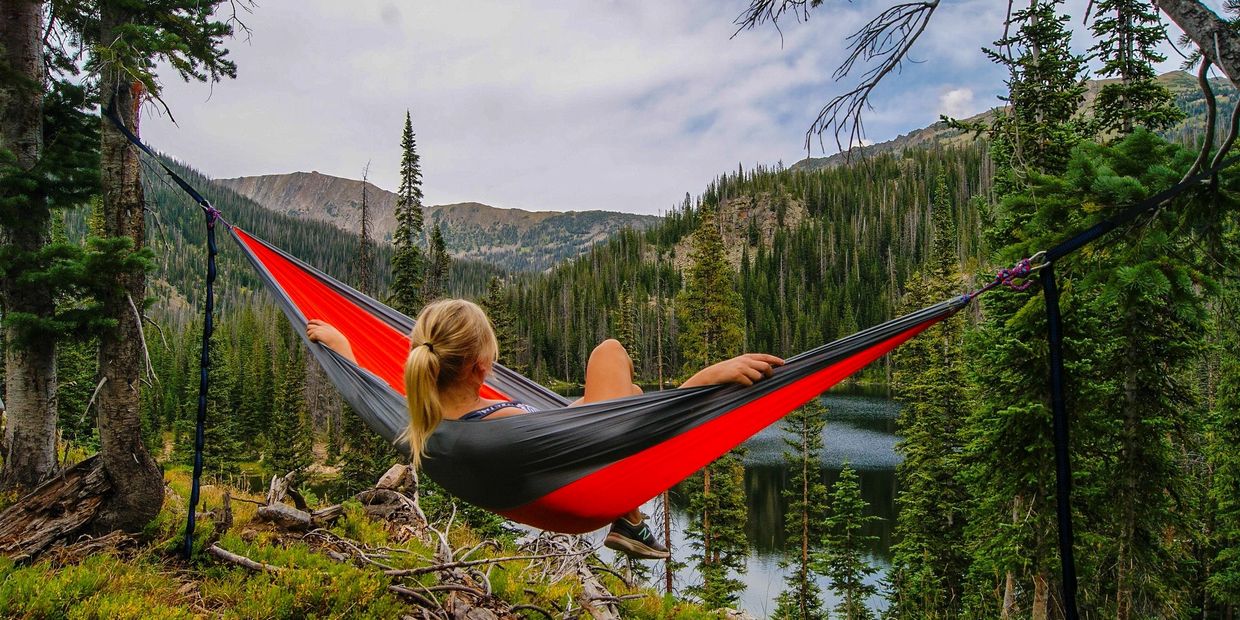 Woman relaxing in a hammock in the forest