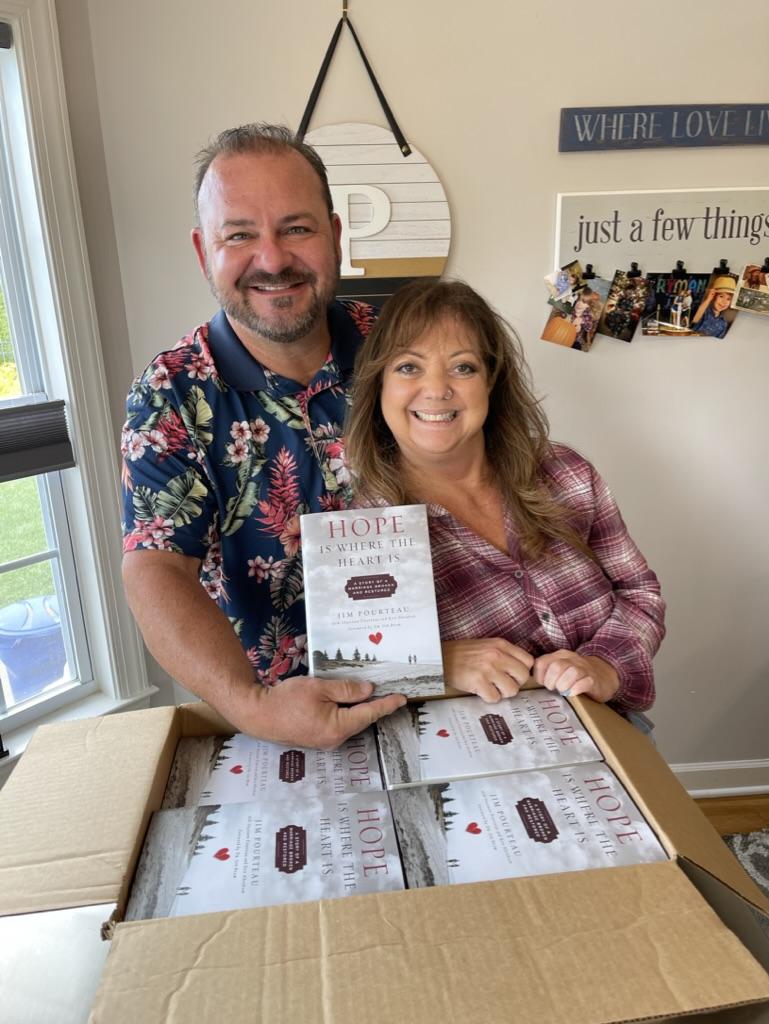 Jim and Shannon Pourteau holding their book Hope Is Where the Heart Is