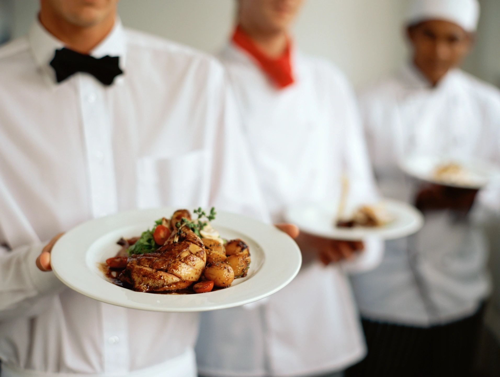 Waiters holding plates of food