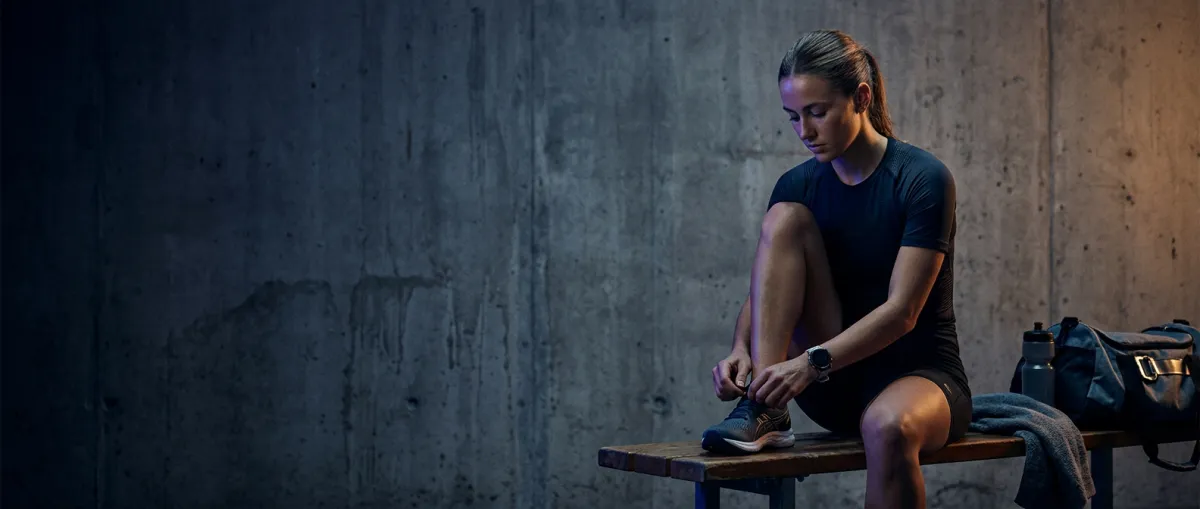 Cinematic visual break showing raw architectural concrete and athlete preparing in dark dramatic lighting