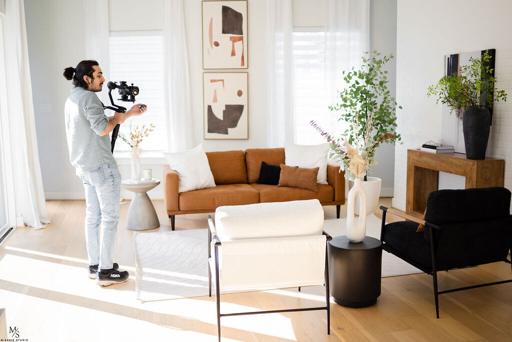 A person filming in a living room setup
